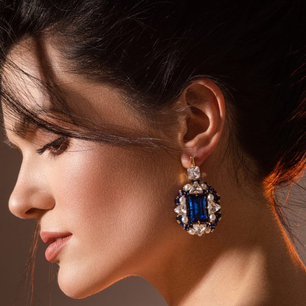 Close up of smiling pretty lady posing while demonstrating designer jewelry. Beauty concept